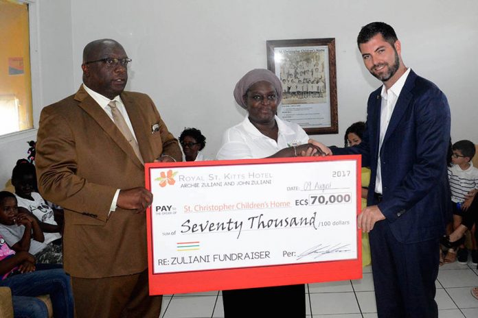 John Zuliani presents cheque to Margaret Stevens in the presence of Prime Minister Dr. the Hon. Timothy Harris